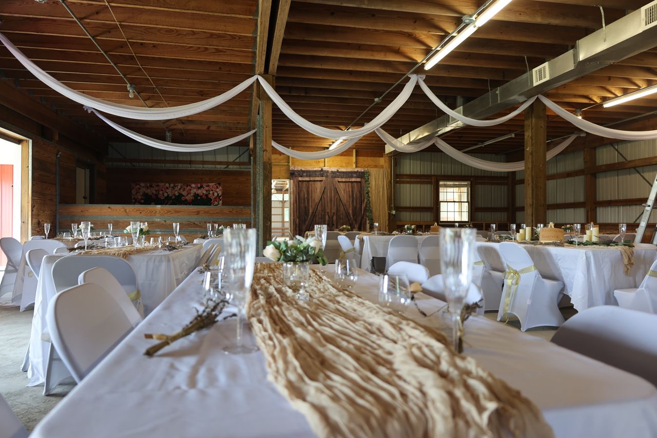 Barn set up for a wedding reception with draped fabric